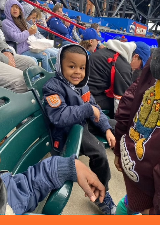 A smiling child sitting in stadium seats